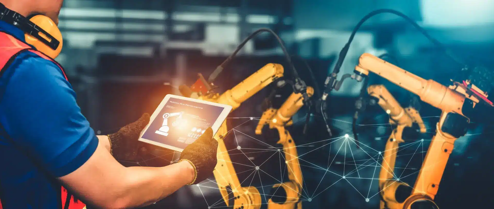 A person in safety gear uses a PDM PLM Mobile App on a tablet to monitor or control robotic arms in an industrial setting, with digital network graphics overlayed.