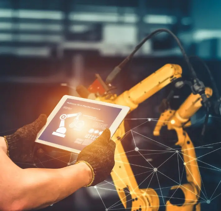 Person wearing gloves operates a robotic arm using a digital tablet interface in an industrial setting, leveraging Product Data Management with network connection graphics overlayed.